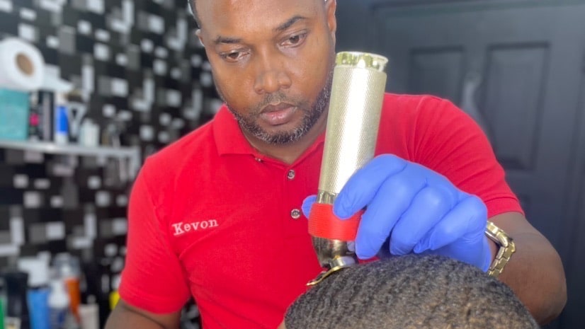 Kevon Stafford cutting a client's hair at Military Cutz in Arima